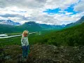 Ett barn funderar på den storslagna utsikten under en vandring med barn i fjällen.