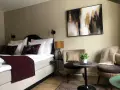Mysigt hotellrum inredning med stor säng, bekväma fåtöljer och modern konst.
