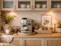 En mysig kaffestation hemma med espressomaskin, kaffebönor i burkar, en vit kopp och en grön växt.