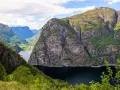Majestätiska bergsklippor reser sig över en mörk fjord, en vy som lockar till en oförglömlig **aurlandsdalen vandring**.