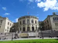 Storslagen byggnad med norsk flagga, en av de mest sevärda platserna att se i Oslo.