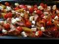 En härlig grekisk pyttipanna med kyckling, potatis, tomater, paprika och fetaost i en ugnsform.