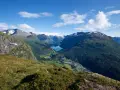 Paragliders svävar över Loen, Norge, med en hisnande utsikt över fjord och berg.