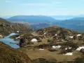 Vacker utsikt över Ulriken i Bergen med små sjöar och snöfläckar på bergssluttningarna.