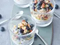 Två glas med overnight oats, toppade med blåbär, nötter och honung. Perfekt frukost!