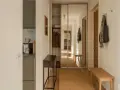 Liten hall inspiration med skjutdörrsgarderob i spegelglas, en smal konsol och en bänk i trä.
