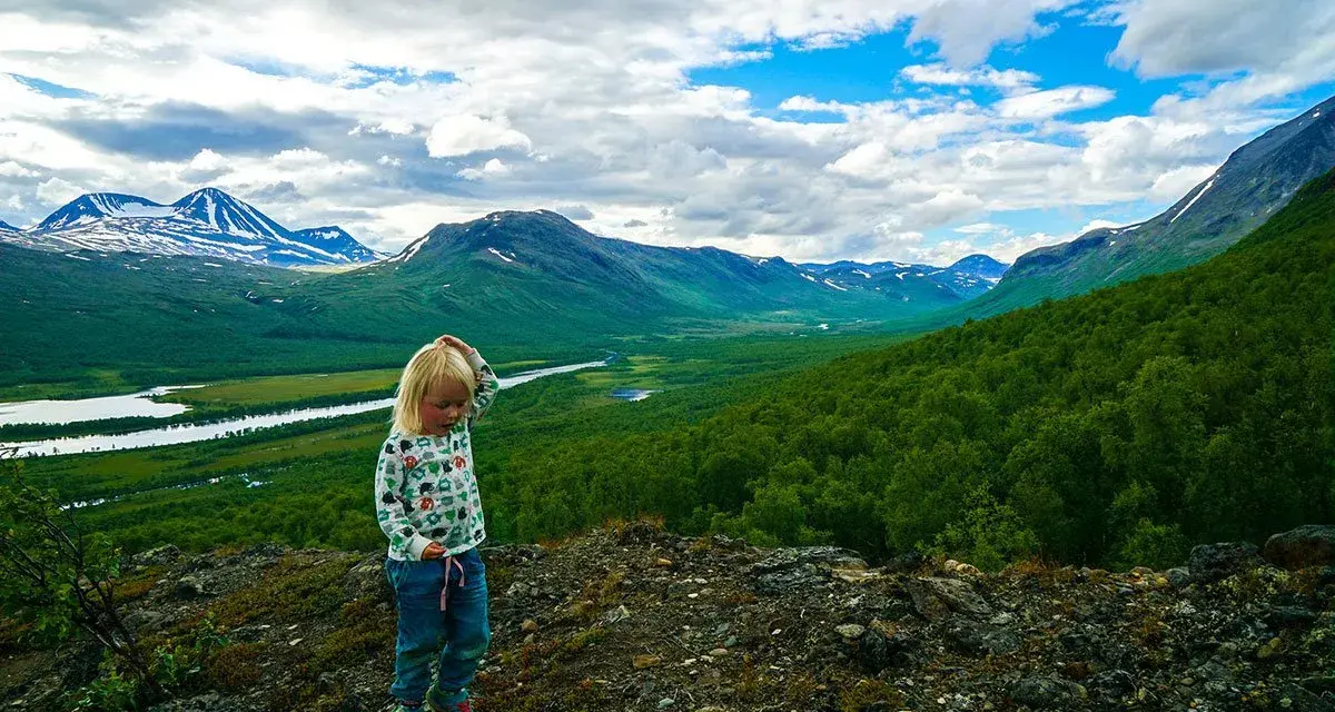 Ett barn funderar på den storslagna utsikten under en vandring med barn i fjällen.