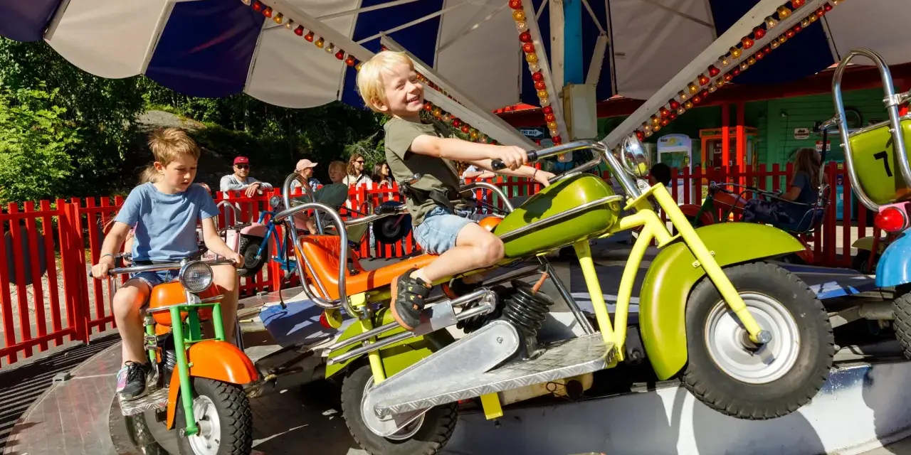 Barn njuter av en motorcykelkarusell på Tivoli Oslo.