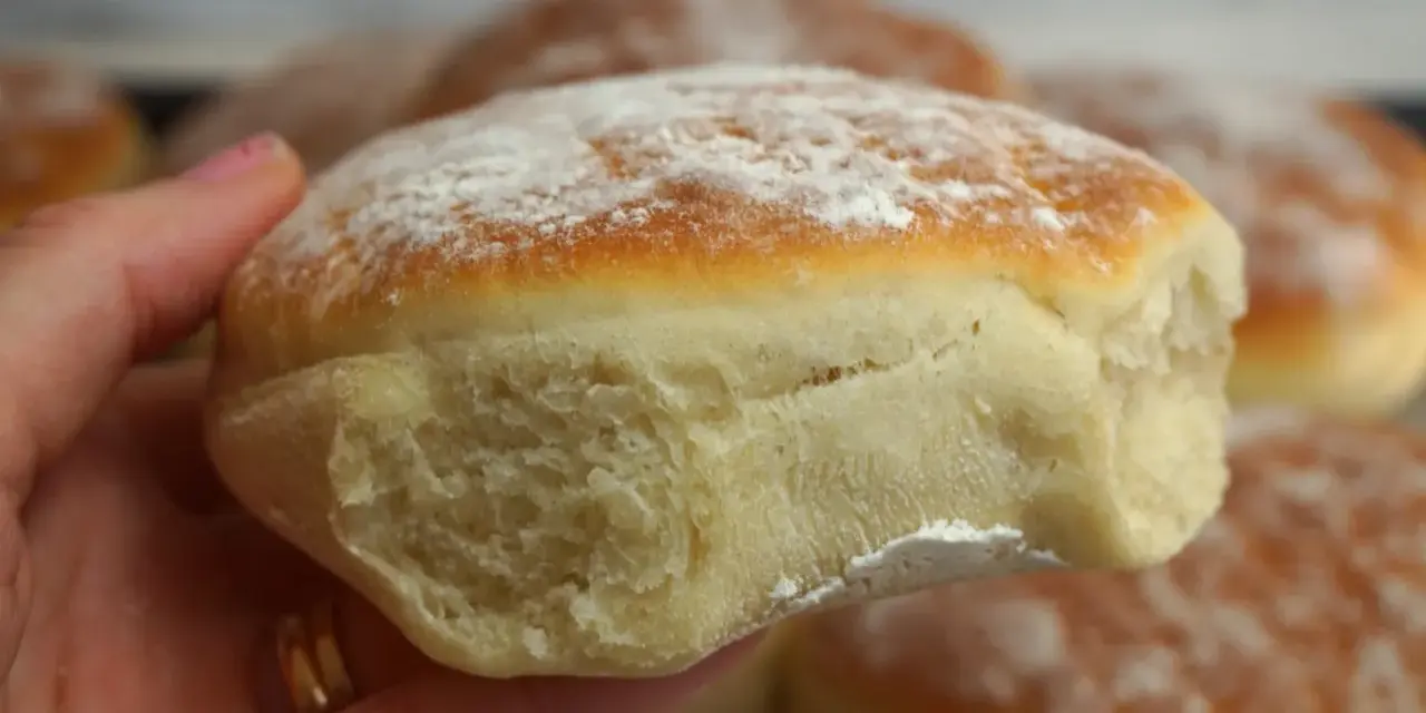 En hand håller en nybakad tekaka, pudrad med mjöl. Perfekt för ett enkelt tekakor recept.