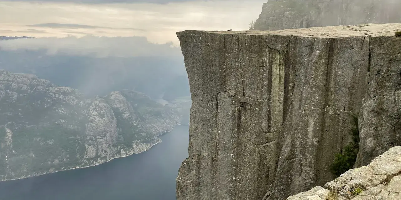Imponerande klippavsats med utsikt över fjord och berg. En del av de fantastiska vandringsleder Norge har att erbjuda.