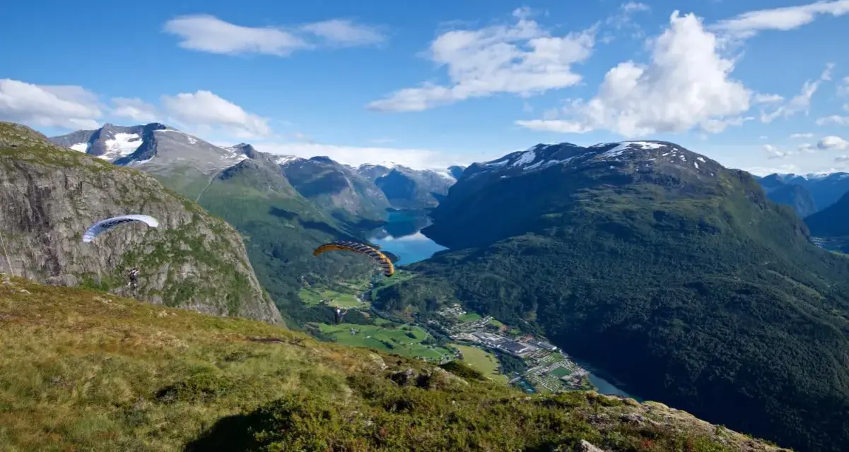 Paragliders svävar över Loen, Norge, med en hisnande utsikt över fjord och berg.
