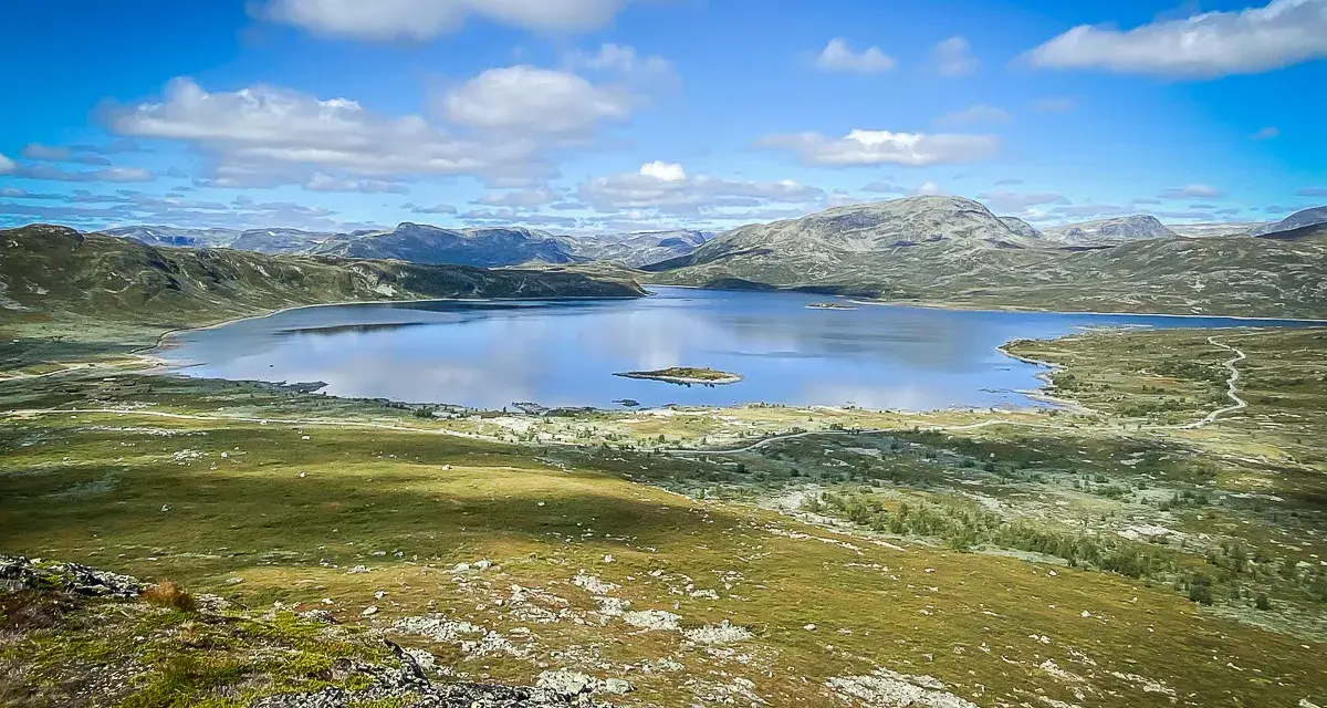 Vacker sjö och berglandskap i Hemsedal, Norge. En liten ö syns i det spegelblanka vattnet.