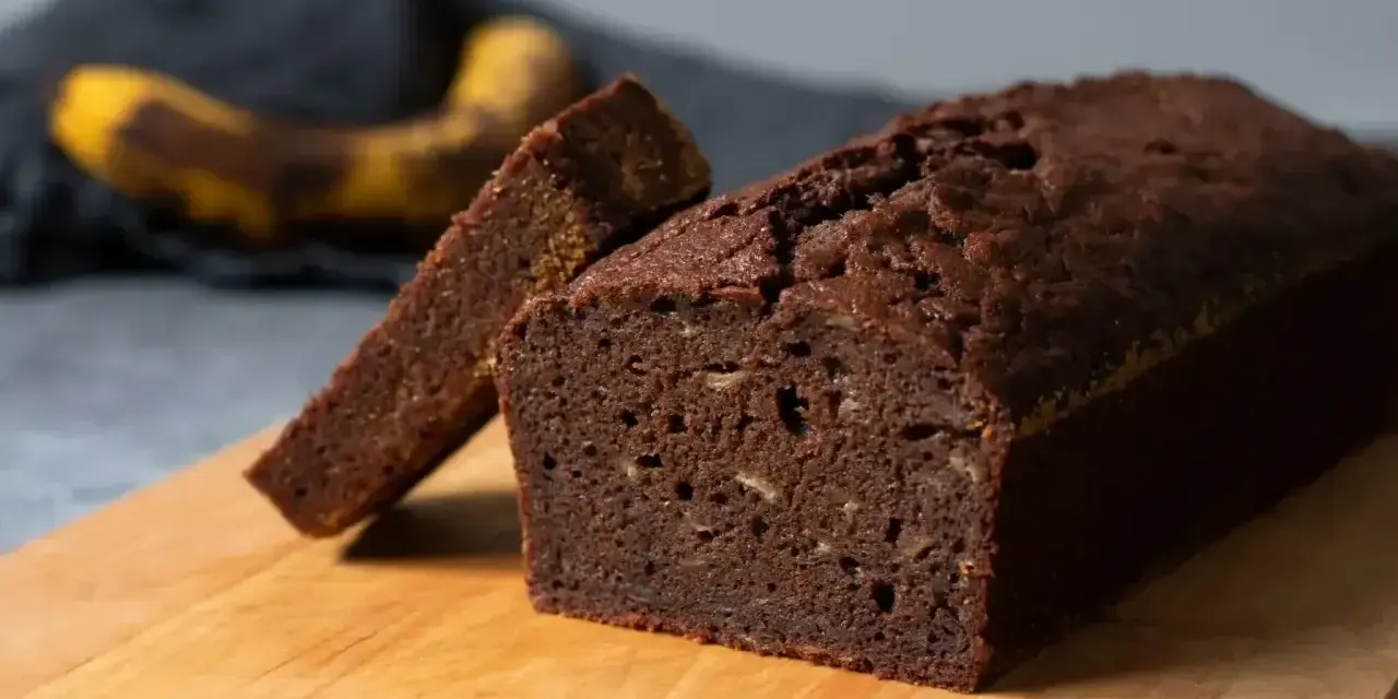 En saftig banankaka utan socker, perfekt för en hälsosam fika. En skiva är uppskuren och en banan syns i bakgrunden.