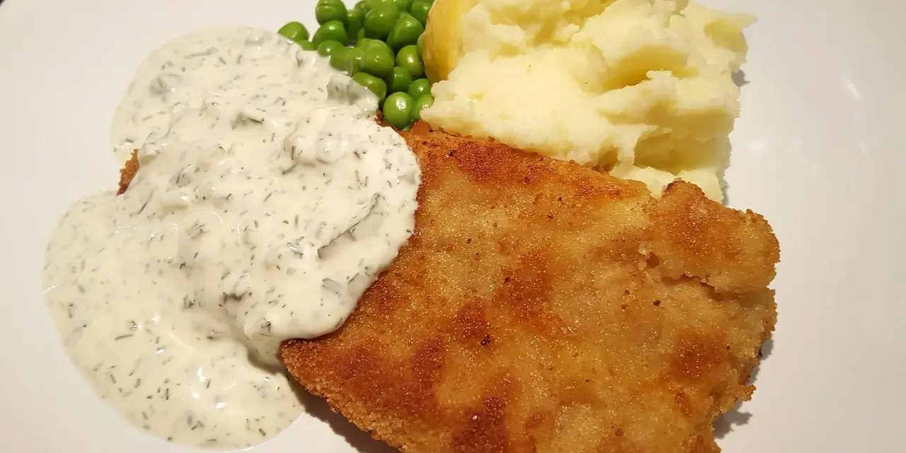 Panerad fisk med potatismos, ärtor och en krämig skolans fisksås.