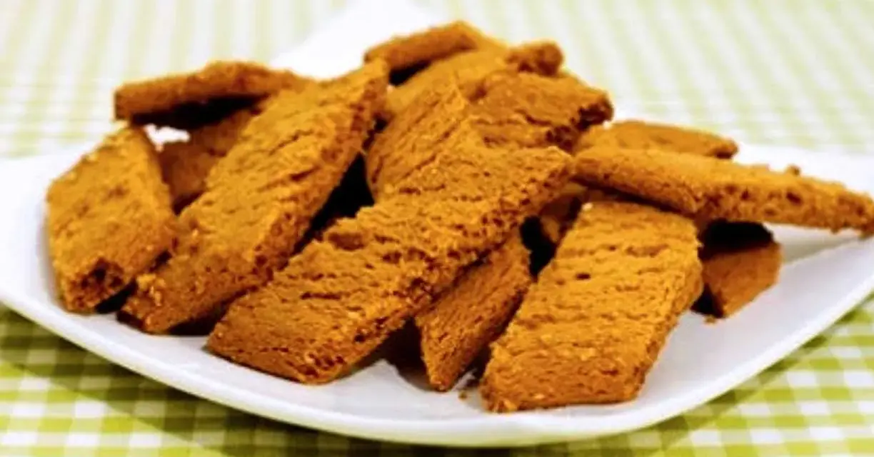 En hög med gyllene kolakakor på en vit tallrik. Perfekt för ett enkelt kolakakor recept.