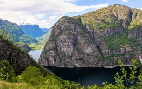Majestätiska bergsklippor reser sig över en mörk fjord, en vy som lockar till en oförglömlig **aurlandsdalen vandring**.