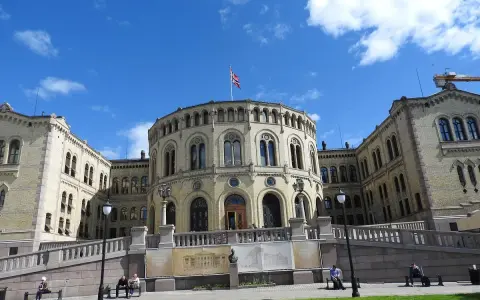 Storslagen byggnad med norsk flagga, en av de mest sevärda platserna att se i Oslo.