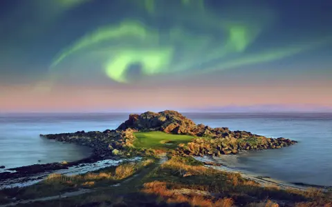 En unik golfbana i Norge under norrsken. En grönskande golfgreen omgiven av klippor och hav, med ett magiskt norrsken som lyser upp himlen.