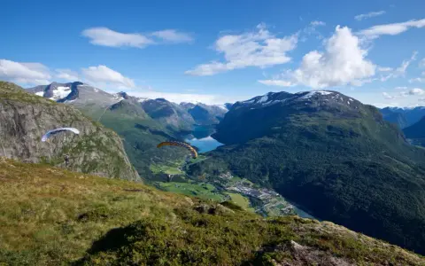 Paragliders svävar över Loen, Norge, med en hisnande utsikt över fjord och berg.