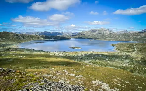 Vacker sjö och berglandskap i Hemsedal, Norge. En liten ö syns i det spegelblanka vattnet.