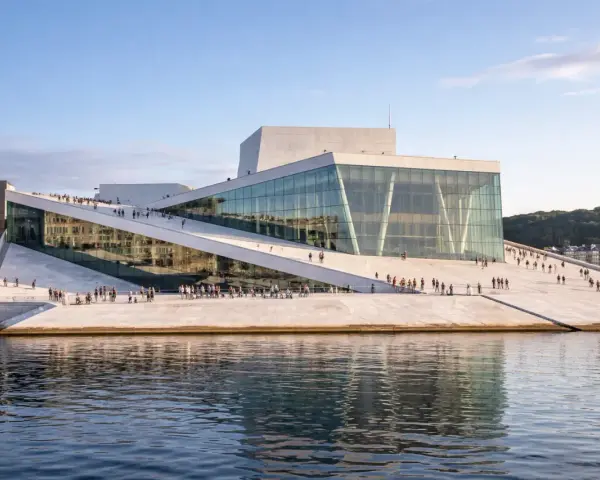 Oslo Operahus, en arkitektonisk pärla vid vattnet, liknar en isberg som reser sig ur fjorden. En populär plats för både turister och lokalbefolkning, likt de som besöker Oslo museer.