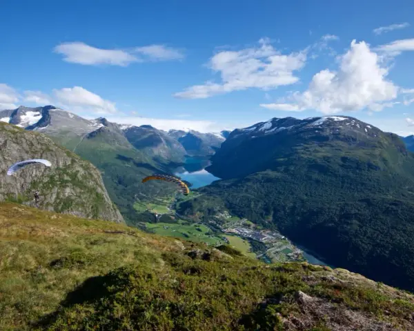 Paragliders svävar över Loen, Norge, med en hisnande utsikt över fjord och berg.