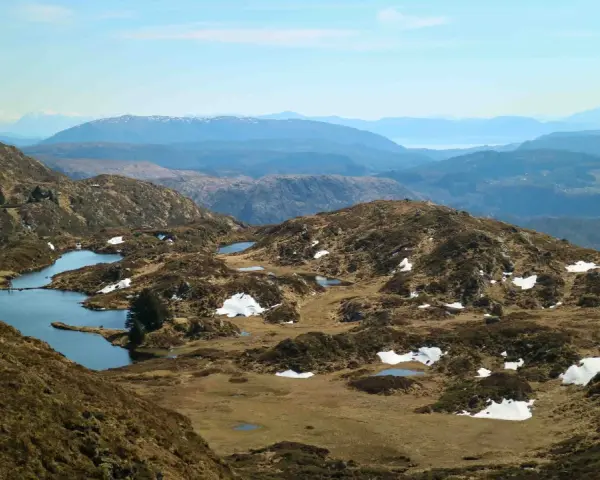 Vacker utsikt över Ulriken i Bergen med små sjöar och snöfläckar på bergssluttningarna.