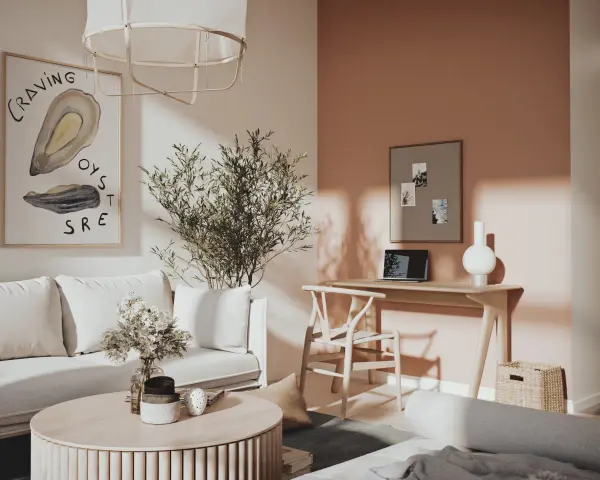 Ett inrett litet rum med en bekväm soffa, ett runt soffbord med blommor och en arbetsplats vid ett fönster.