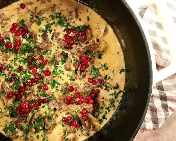 Krämig renskav i panna, toppad med lingon och persilja. Ett klassiskt renskav recept som doftar svensk höst.