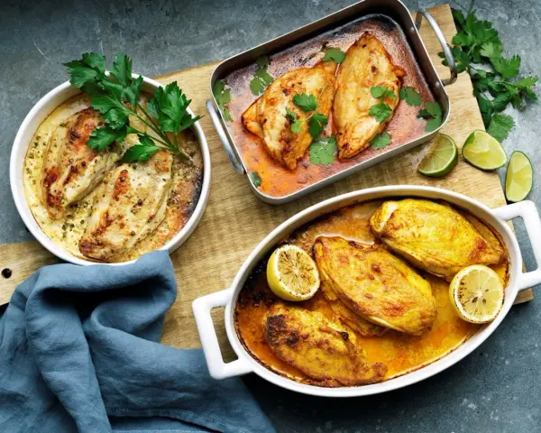Tre ugnsbakade kycklinglårfile i olika former, redo att serveras. Ett perfekt kycklinglårfile recept för middagen.