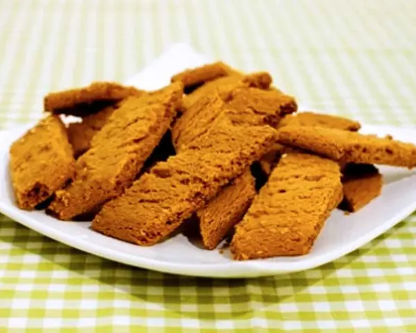 En hög med gyllene kolakakor på en vit tallrik. Perfekt för ett enkelt kolakakor recept.