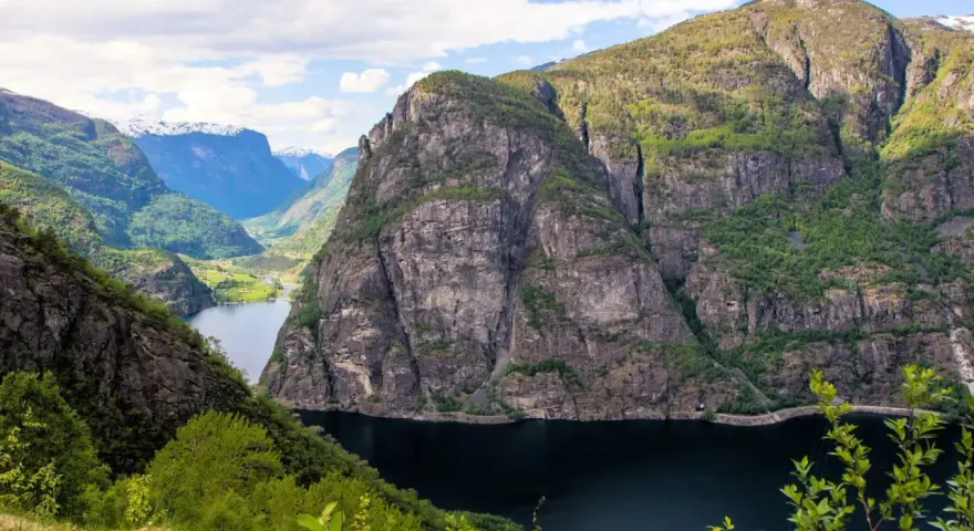 Majestätiska bergsklippor reser sig över en mörk fjord, en vy som lockar till en oförglömlig **aurlandsdalen vandring**.