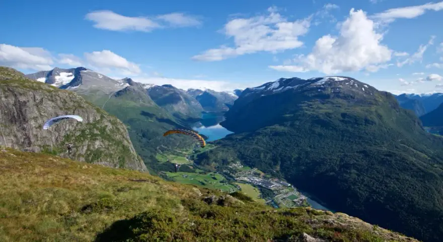 Paragliders svävar över Loen, Norge, med en hisnande utsikt över fjord och berg.