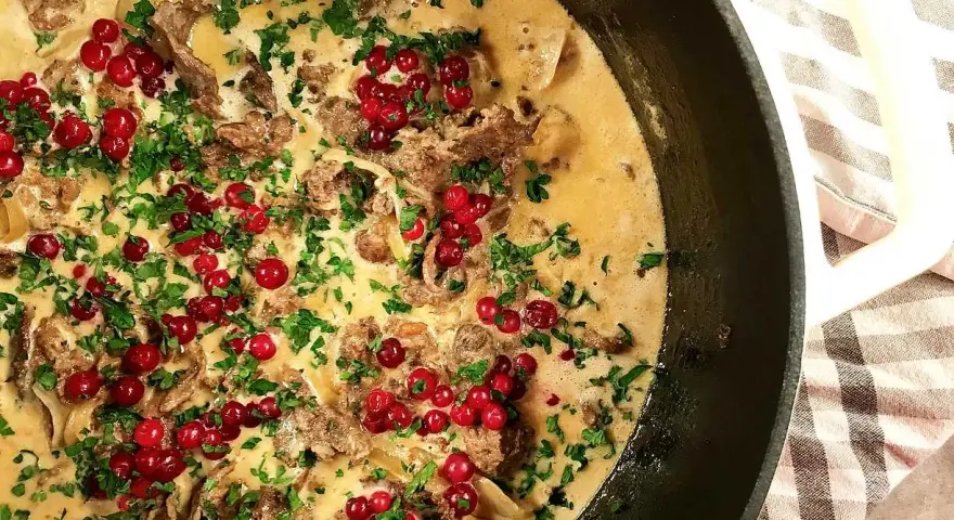 Krämig renskav i panna, toppad med lingon och persilja. Ett klassiskt renskav recept som doftar svensk höst.