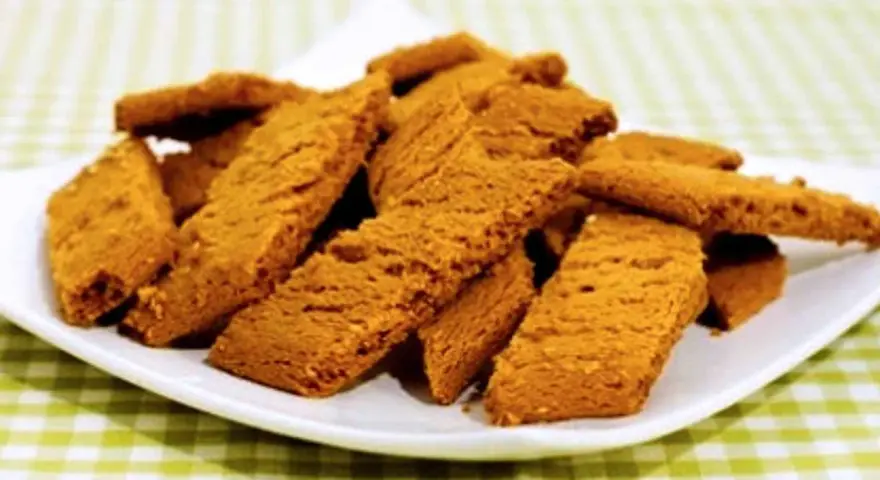 En hög med gyllene kolakakor på en vit tallrik. Perfekt för ett enkelt kolakakor recept.