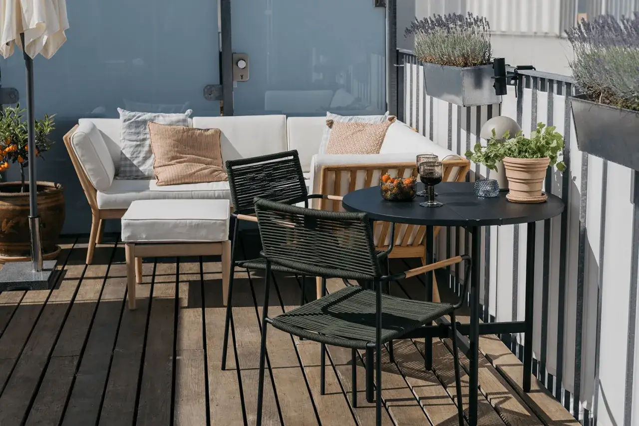En mysig liten balkong med soffa, bord och stolar. Perfekt f&ouml;r en fika i solen.