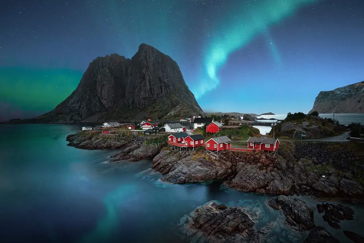 Röda fiskestugor vid havet under norrsken i Hadeland, Norge. En magisk natt.