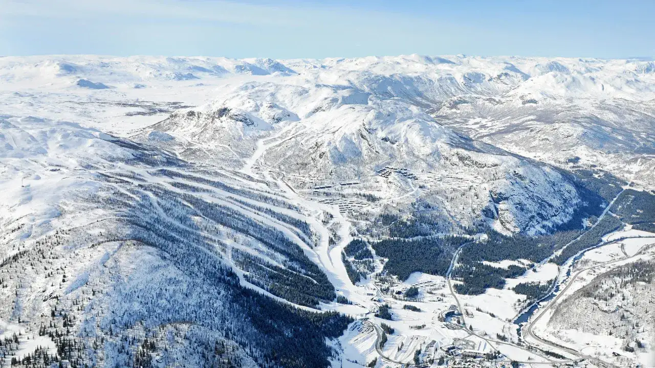 Vacker vy över Hemsedal skidor med snöklädda berg, pister och byar. Perfekt för en vintersemester.