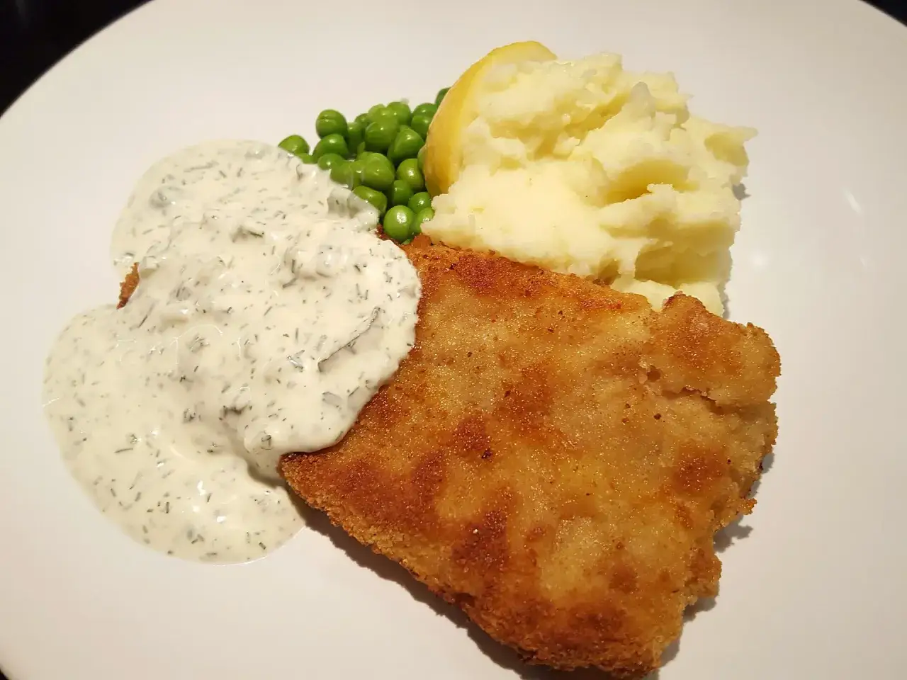 Panerad fisk med potatismos, ärtor och en krämig sås som påminner om skolans fisksås.