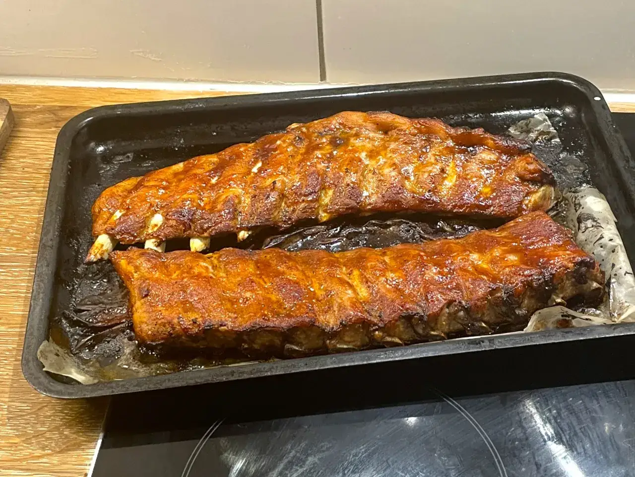 Tv&aring; ugnsbakade kamben, glaserade och gyllene, ligger p&aring; en pl&aring;t. Doften av BBQ sprider sig i k&ouml;ket.