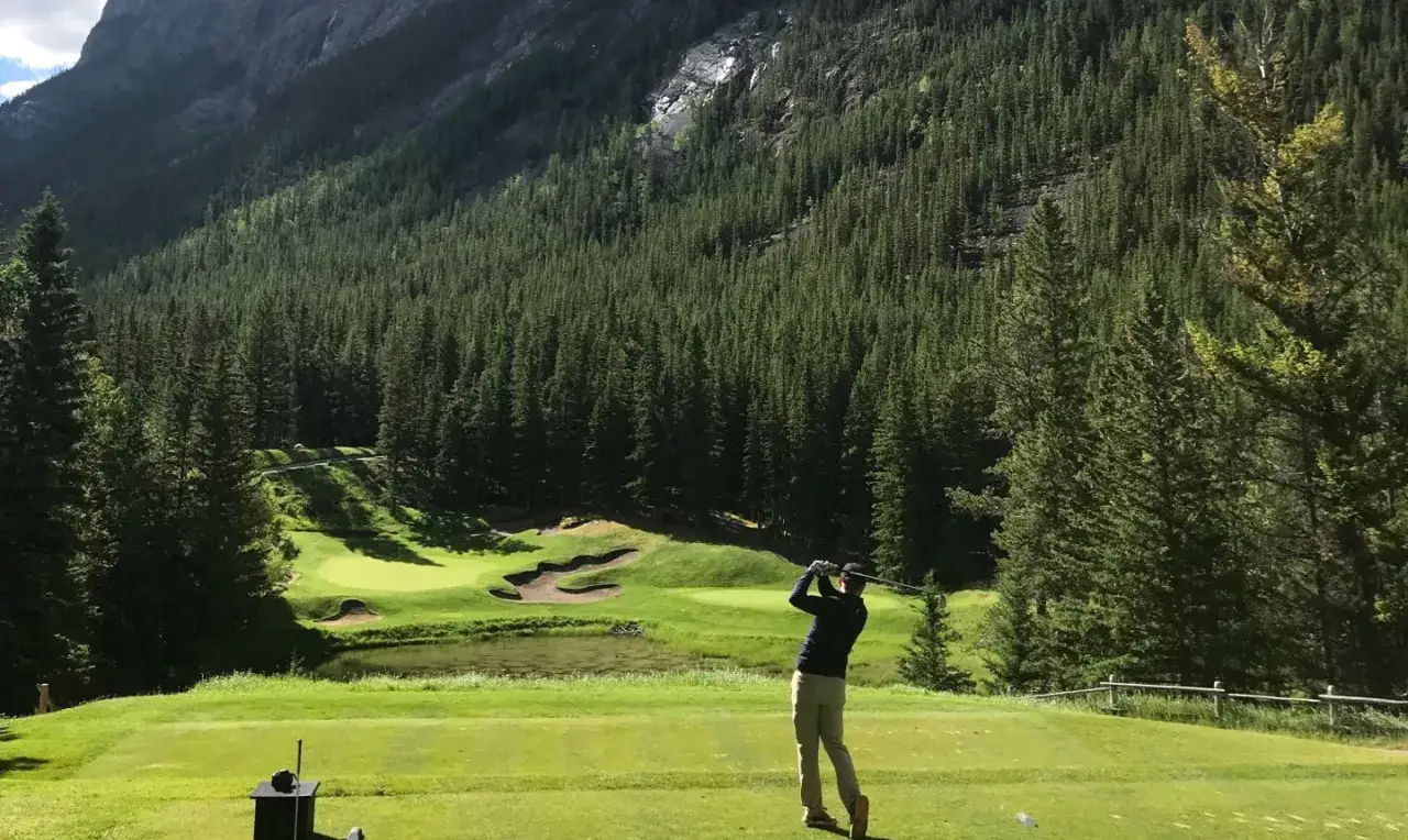 En golfare svingar klubban p&aring; en bana omgiven av en t&auml;t granskog och h&ouml;ga berg. En dr&ouml;m f&ouml;r golf norge.