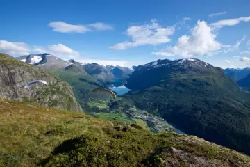 Paragliders svävar över Loen, Norge, med en hisnande utsikt över fjord och berg.