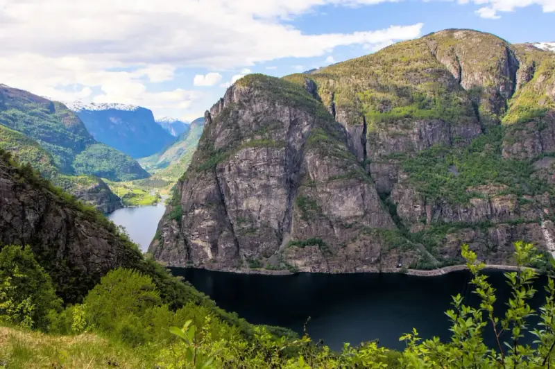 Majestätiska bergsklippor reser sig över en mörk fjord, en vy som lockar till en oförglömlig **aurlandsdalen vandring**.